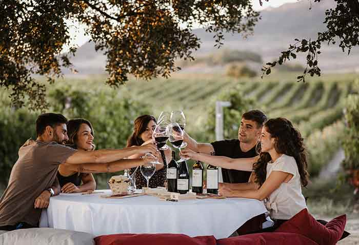 Un grupo de jóvenes brindan con vinos de Muga en pleno viñedo